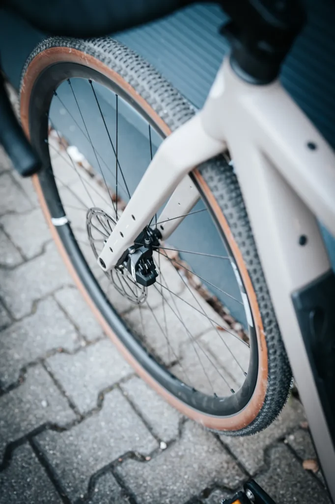 Vorderrad des beigen ROSE Backroad AL mit SRAM-Bremssattel und Continental-Reifen