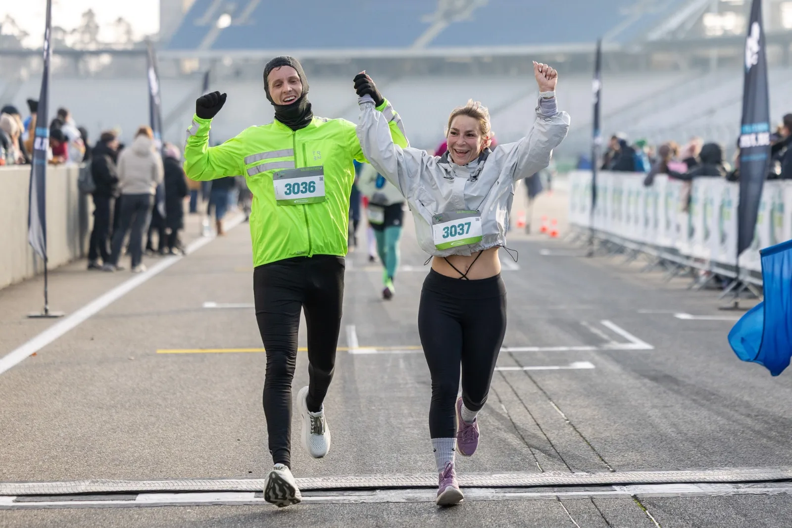 Alex und Geri von DealGrid laufen gemeinsam beim Halbmarathon der Ring Running Series am Hockenheimring über die Ziellinie