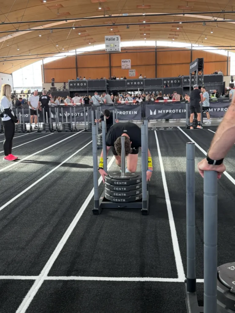 Alex schiebt bei HYROX Karlsruhe 2026 den Sled mit vier 25-kg-Scheiben